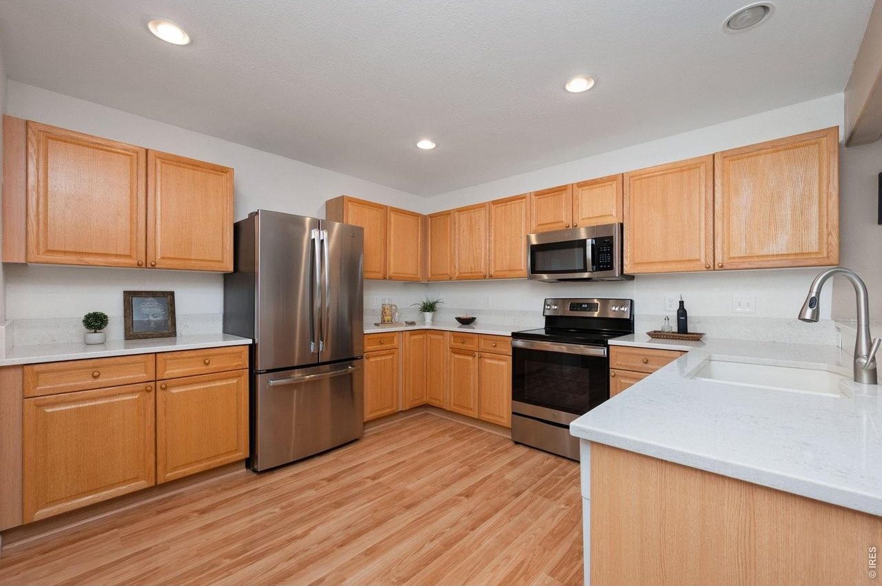 Kitchen with quartz counters, wood cabinets and stainless appliances